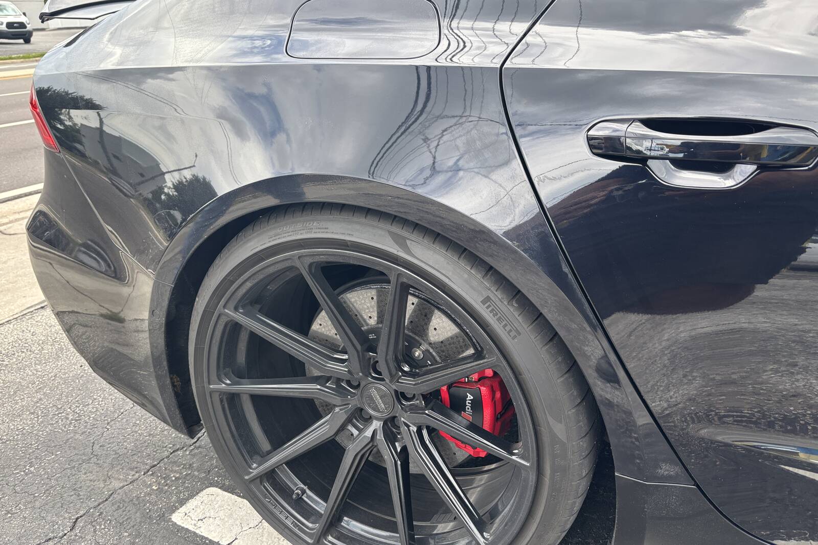 A black Audi after paint work, close on the rear panel and wheel.